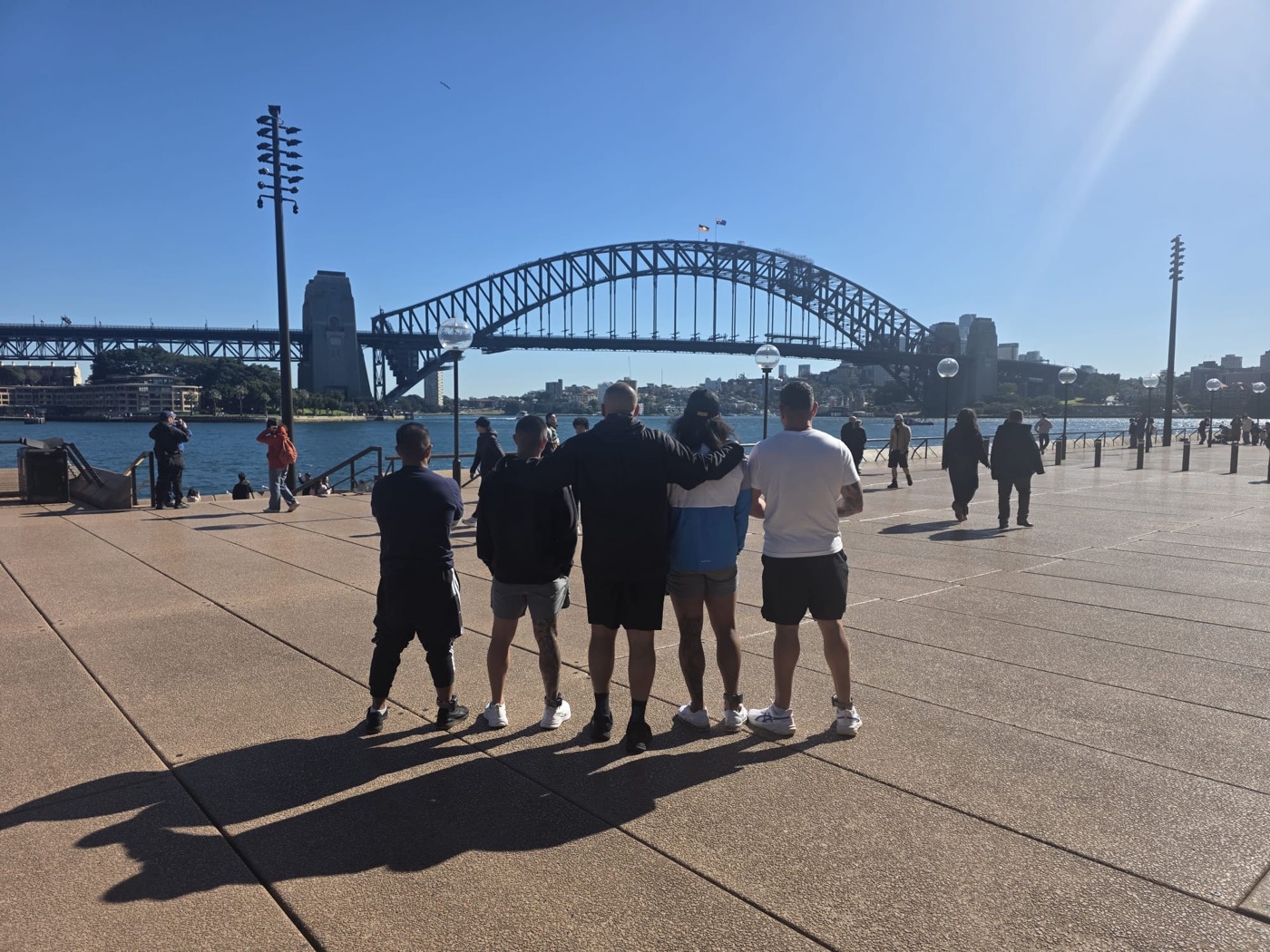 Group looking out to the Sydney Harbour Bridge with the Aboriginal flag flying