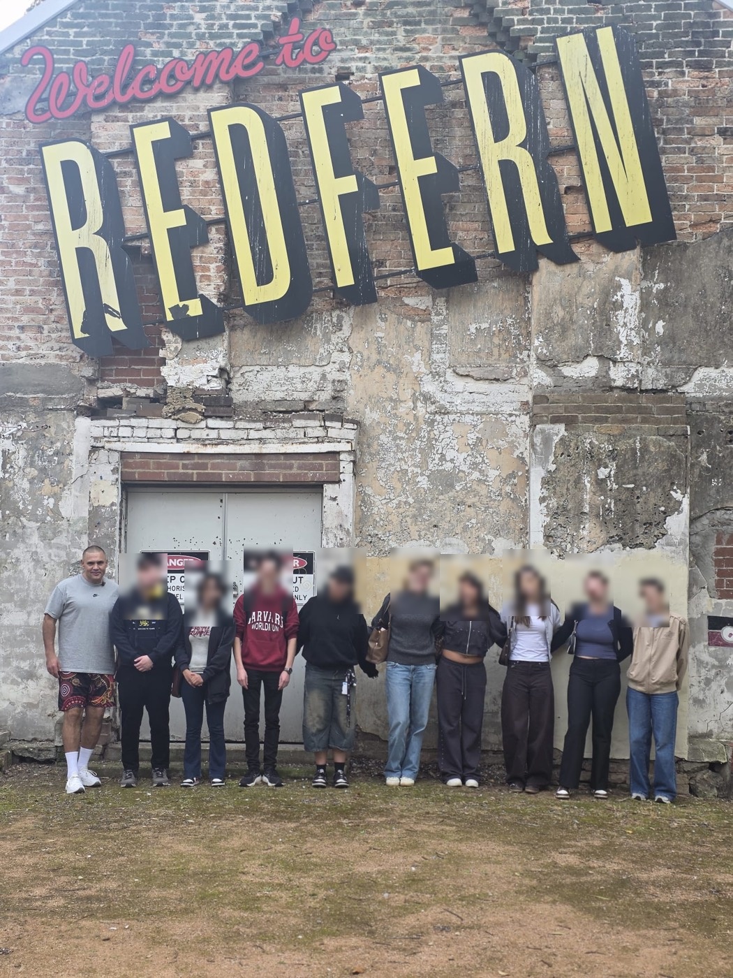 Group beneath the Welcome to Redfern mural